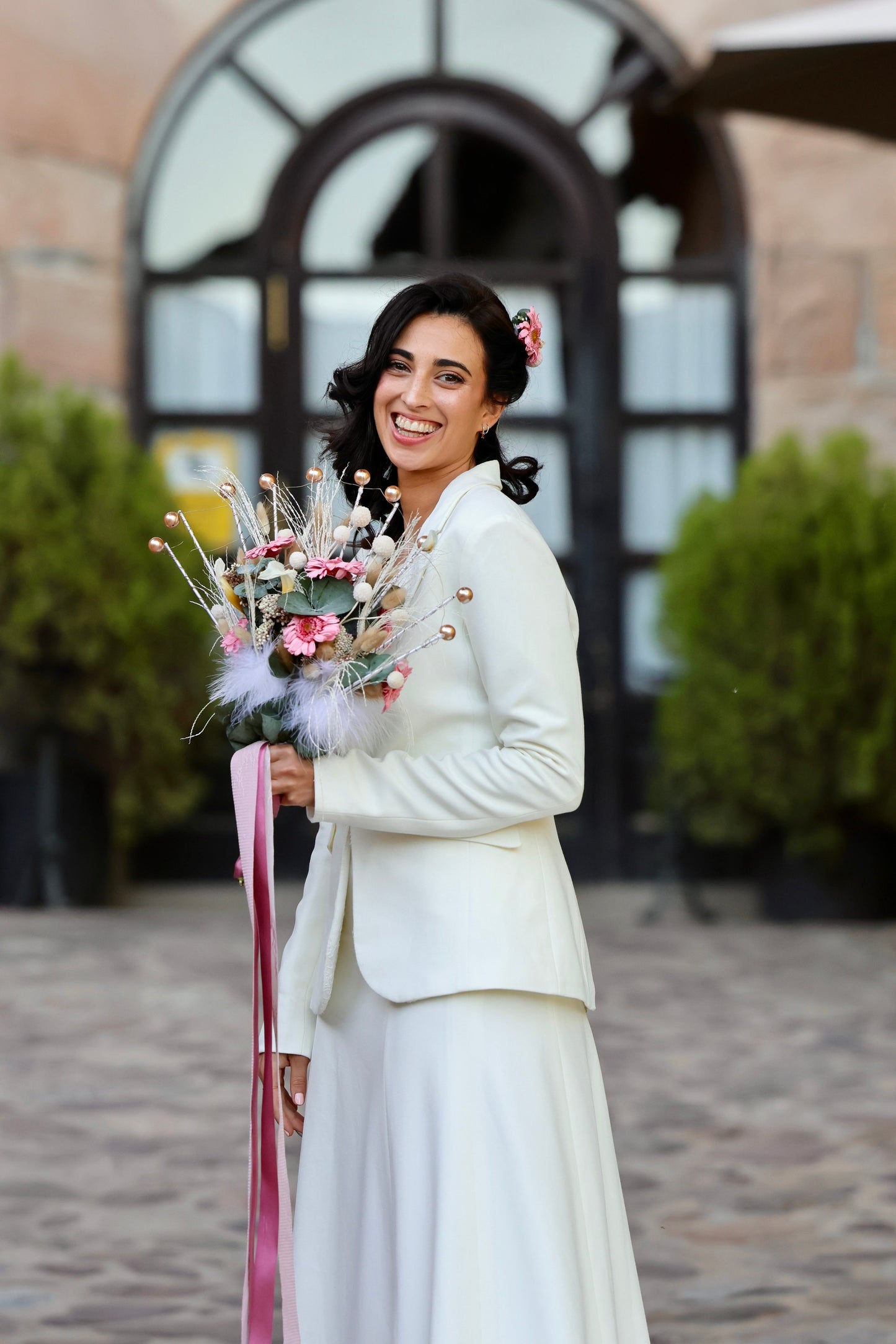Novia moderna sosteniendo ramo de flores preservadas con estructura abanico, tonos rosados y beige, estilo artesanal Montseflower