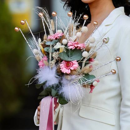 Ramo de novia preservado con gerberas rosadas, eucalipto y miscanthus beige en estructura metálica tipo abanico, estilo moderno y natural