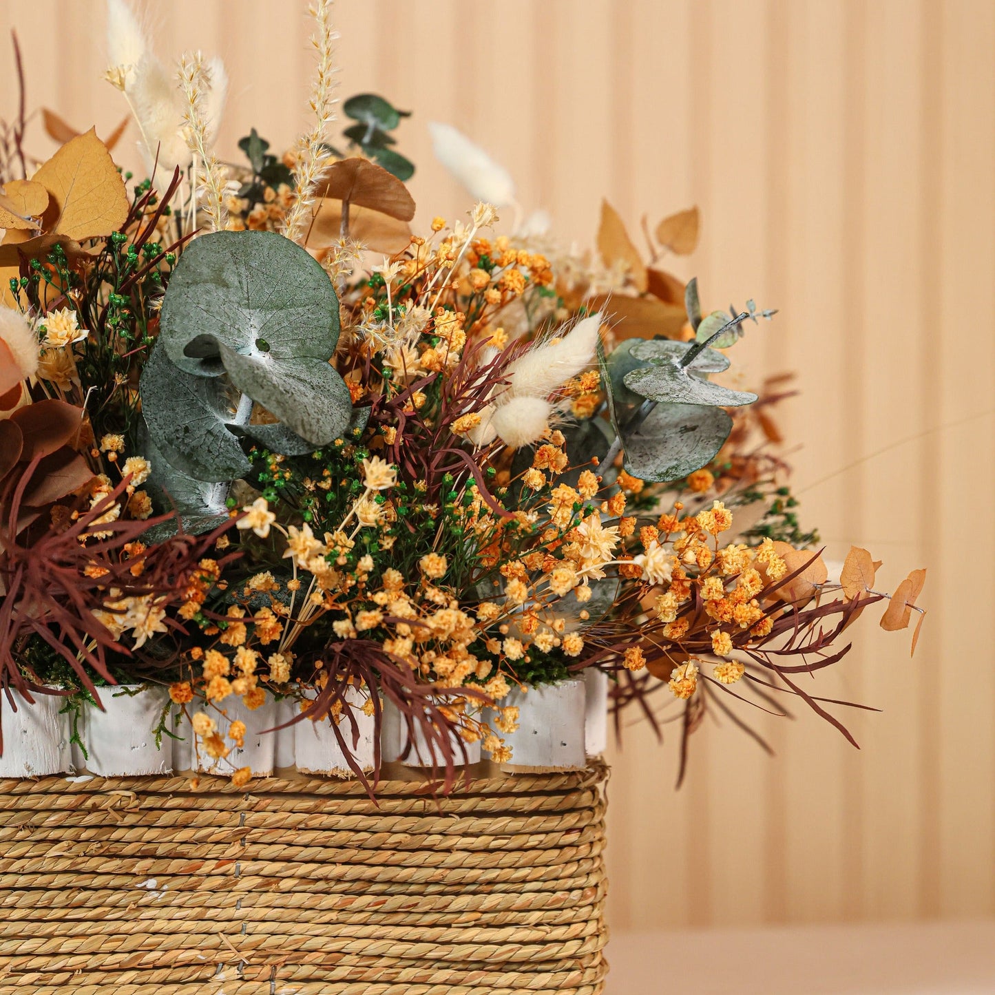 Detalle de flores preservadas burdeos y hojas verdes en composición Toscana de Montseflower