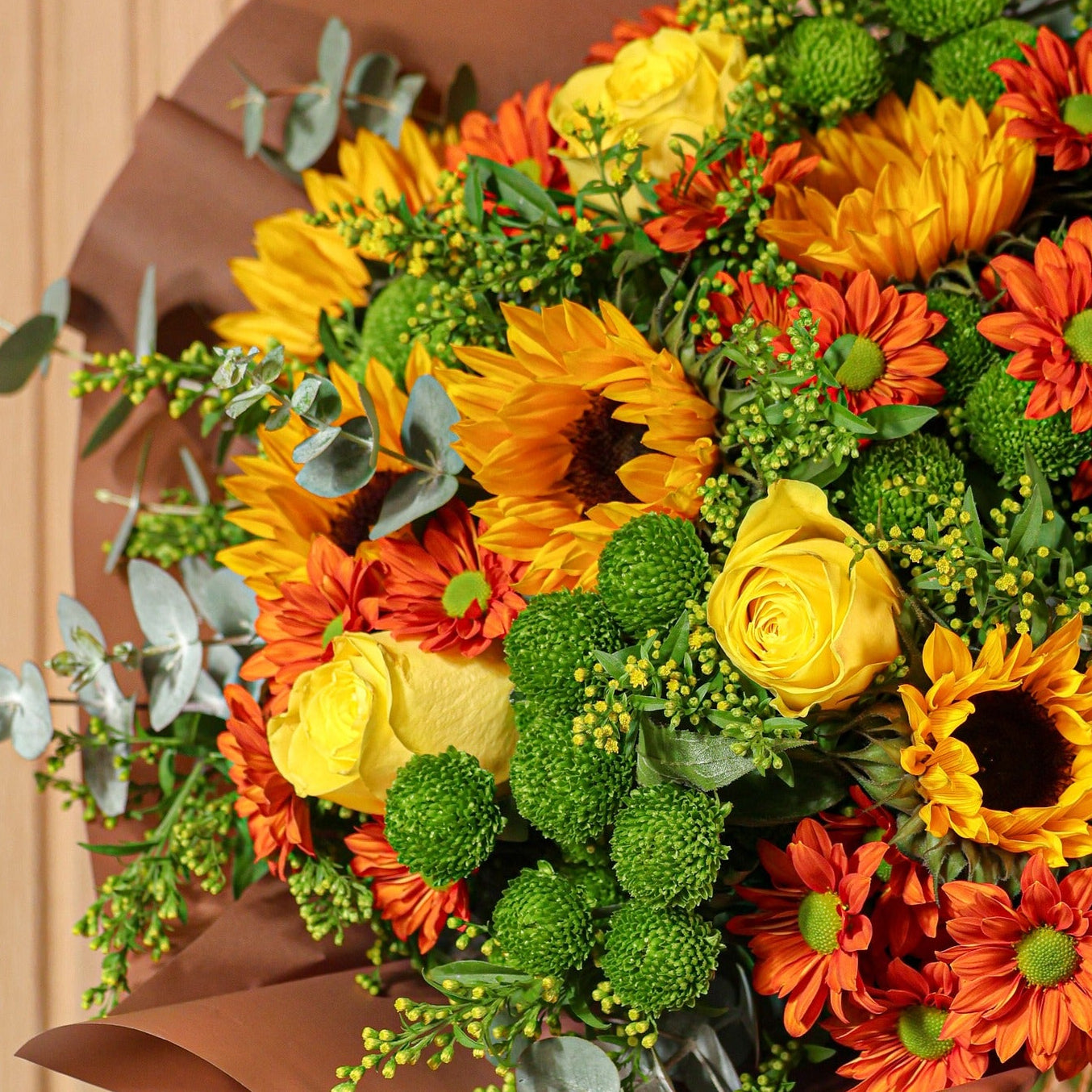 Detalle de girasoles y crisantemos naranjas del ramo Alma de Sol estilo otoñal