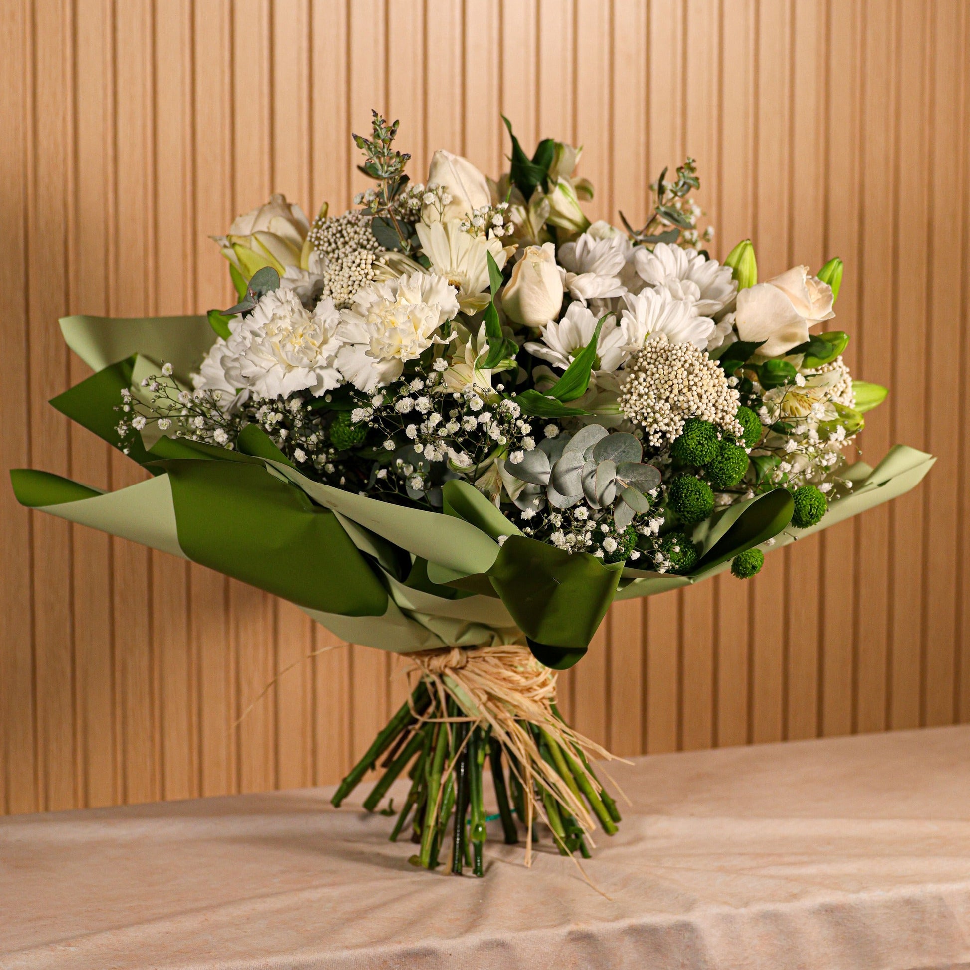 Ramo de flores con rosas blancas, claveles y liliums blancos complementados con eucalipto