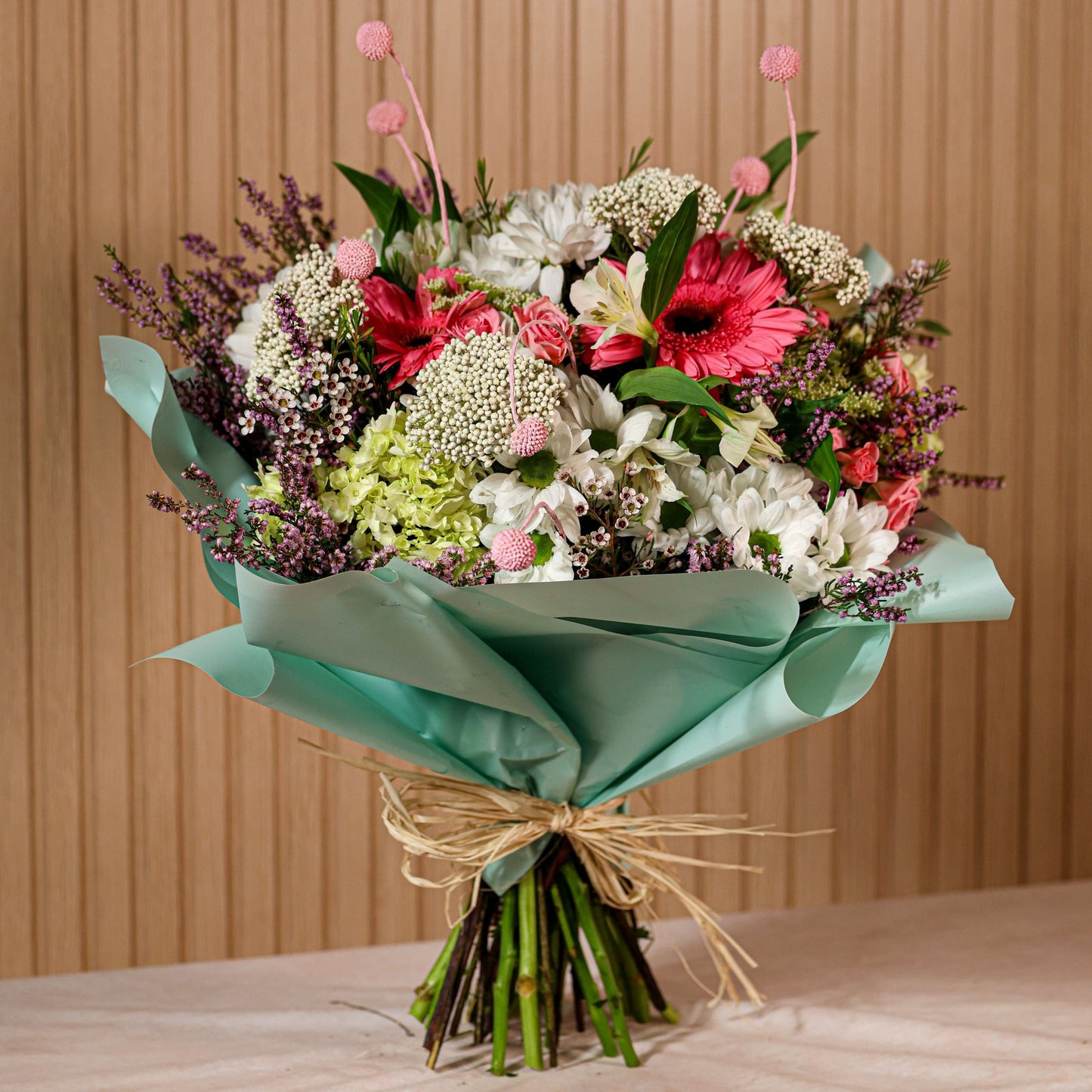 Ramo de flores preservadas Coquette con gerberas rosadas, crisantemos blancos, rosas spray y flores silvestres lilas