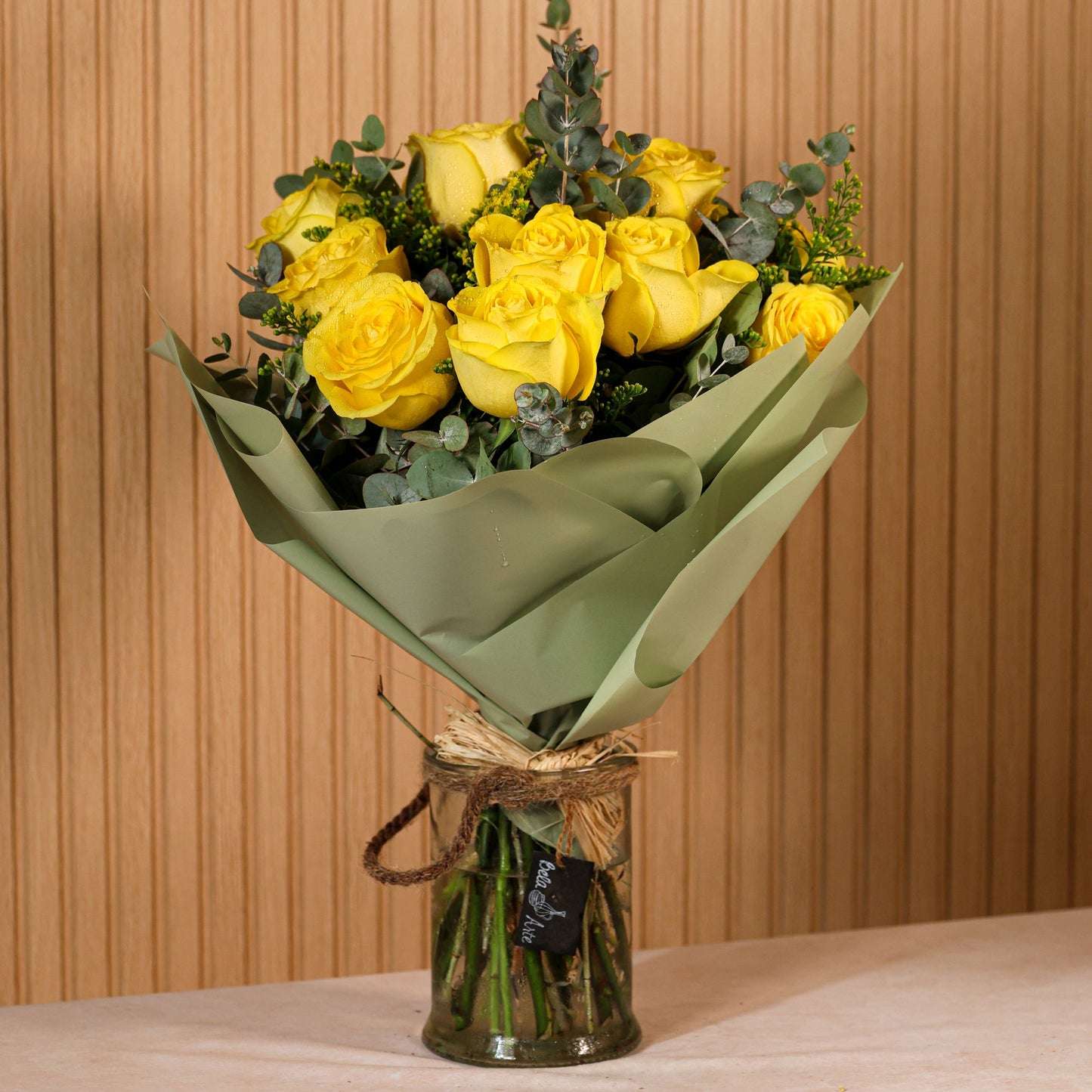 Ramo de 6 rosas amarillas con eucalipto y brezo morado sobre fondo neutro, ideal para decoración o regalo floral duradero