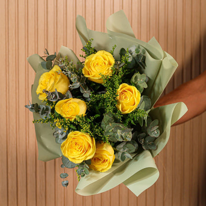 Detalle de rosas amarillas con hojas de eucalipto y flores de brezo en ramo artesanal de Montseflower
