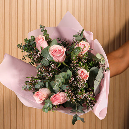 Detalle de rosas rosadas con hojas de eucalipto y flores de cera en ramo artesanal de Montseflower