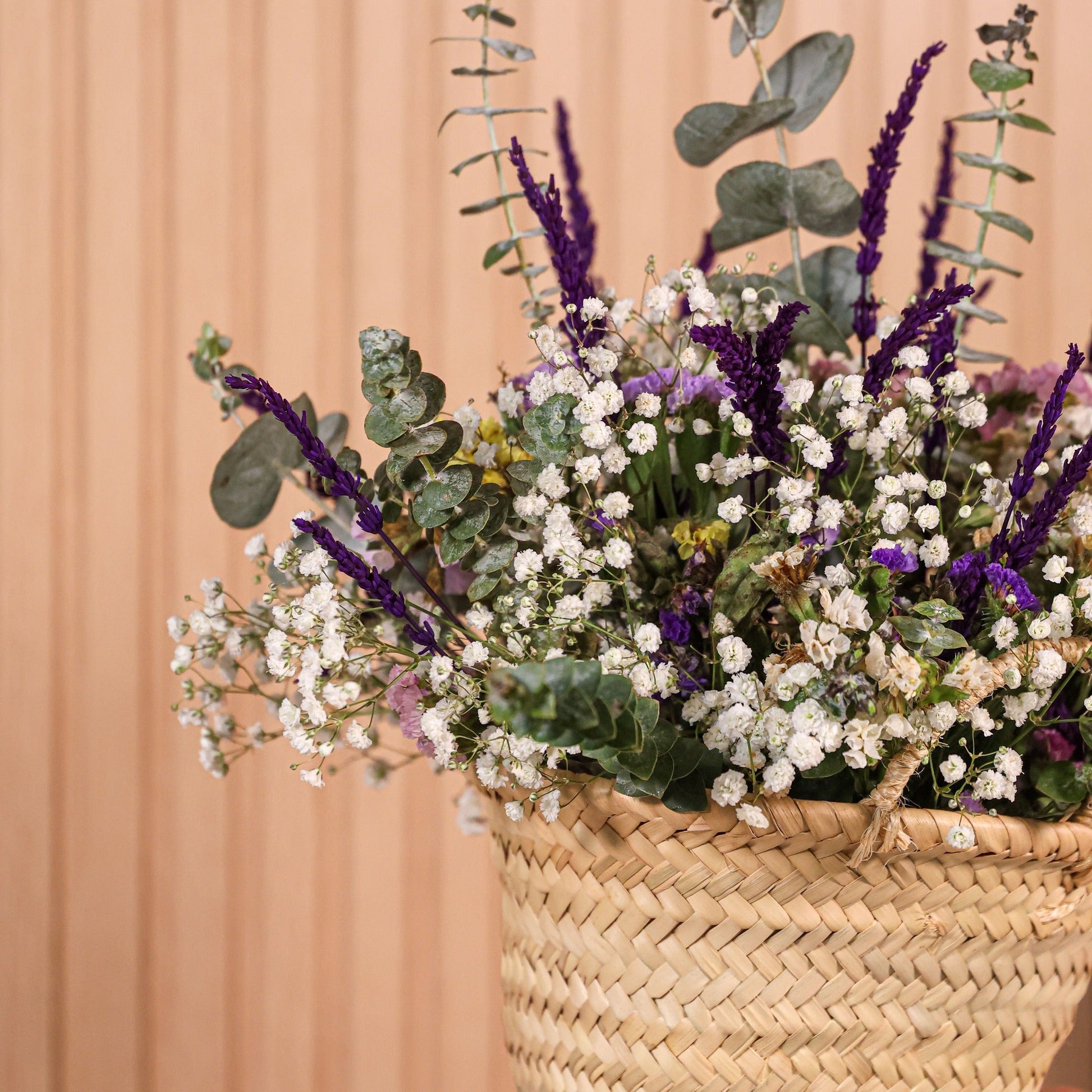 Detalle de flores preservadas coloridas de statice y lavanda en cesta Provenza