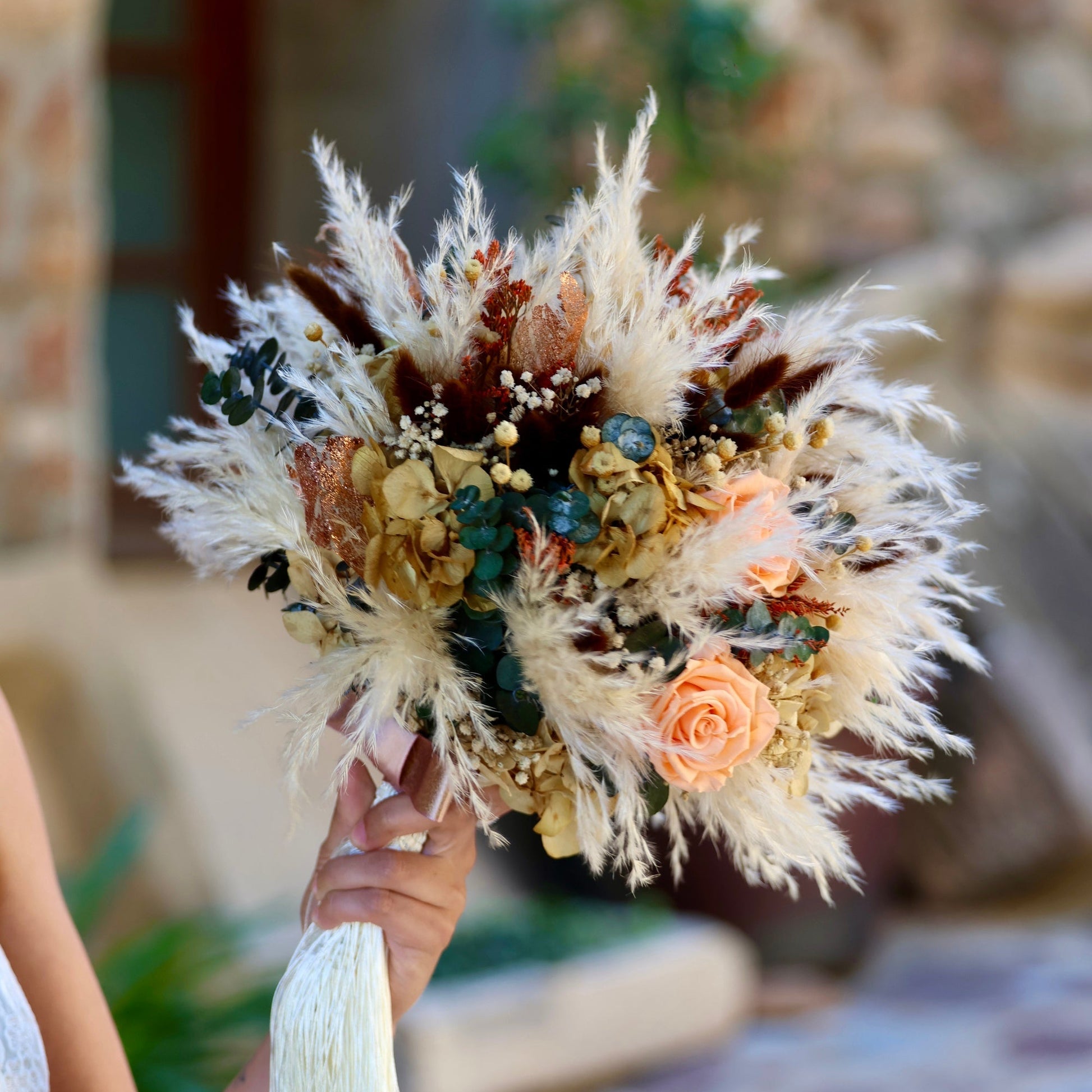 Ramo de novia preservado con rosas coral, miscanthus blanco y lagurus marrón, estilo boho chic para bodas en el campo