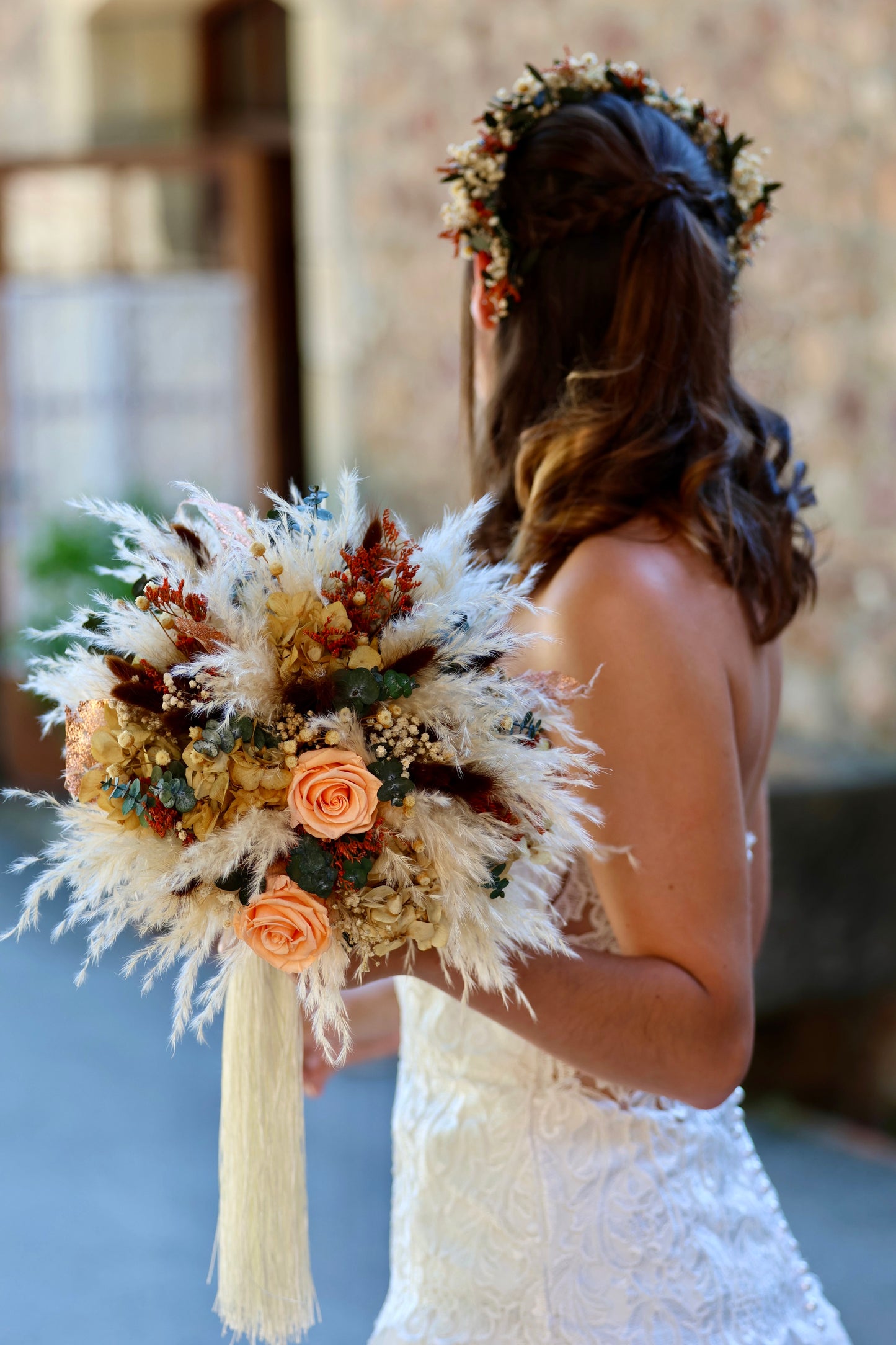 Novia sosteniendo ramo de flores preservadas en tonos coral y beige, estilo bohemio y natural de Montseflower