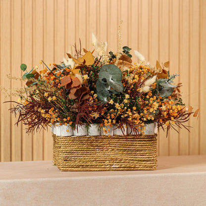 Composición de flores preservadas Toscana en caja de mimbre con tonos ocres, verdes, burdeos y blancos