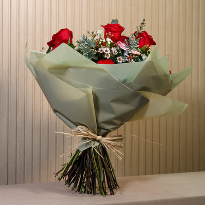 ramo de rosas rojas, flor de arroz y eucaliptus san valentin sobre una mesa